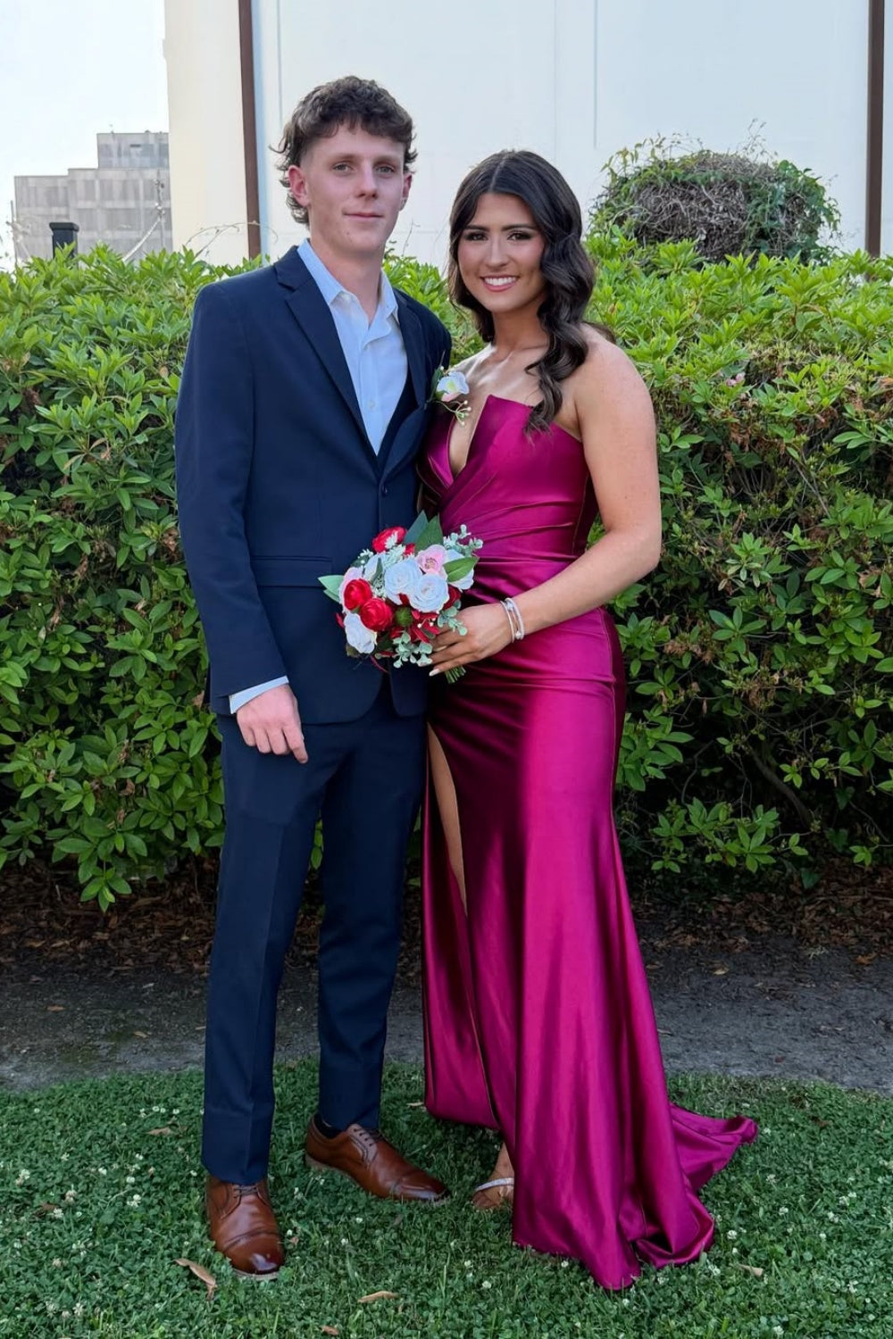 Fuchsia ruched satin prom dress with plunging V-neck and high side slit.