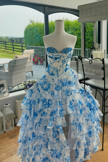 Floral print A-line tiered gown with sweetheart neckline, lace appliques, and side slit.