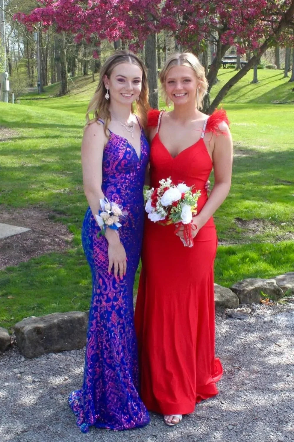 Red V-neck mermaid prom dress featuring luxury diamond straps, feather accents, and an open back.