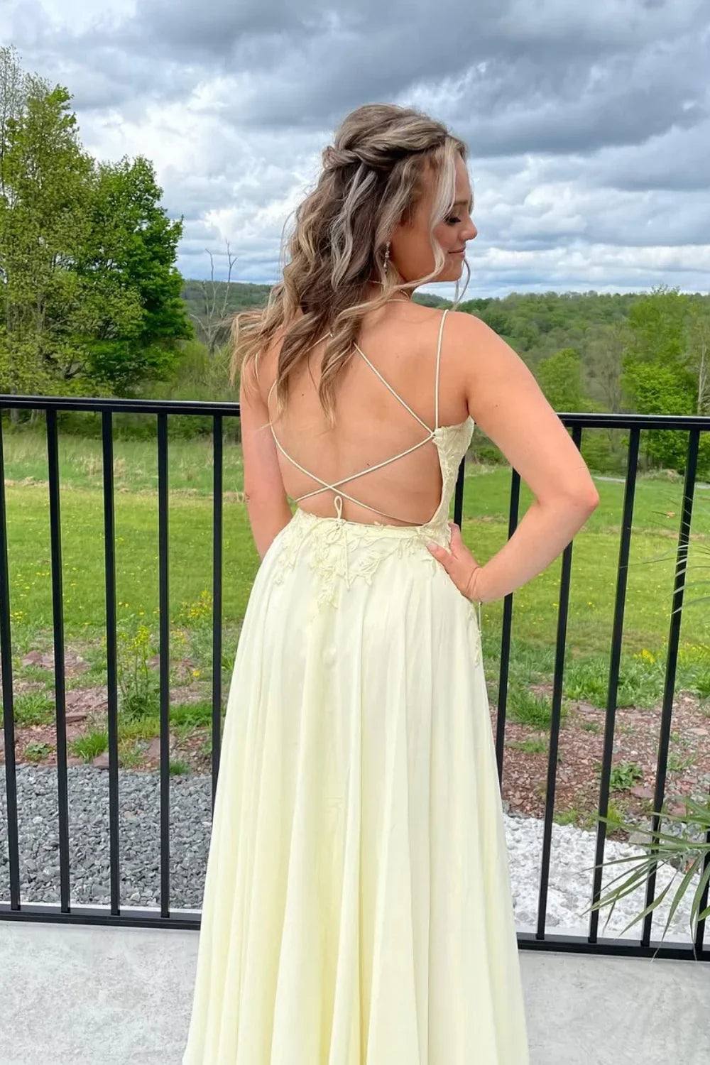 Flowy yellow chiffon A-line prom dress featuring delicate lace appliques and a double strap back design.