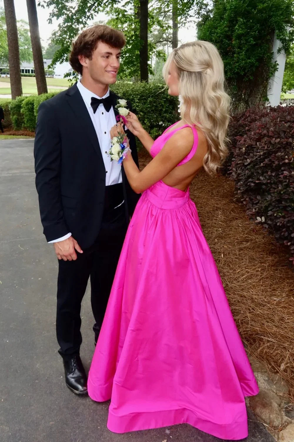 Vibrant hot pink formal gown featuring a plunging V-neckline, waist cut-outs, and a high leg slit.