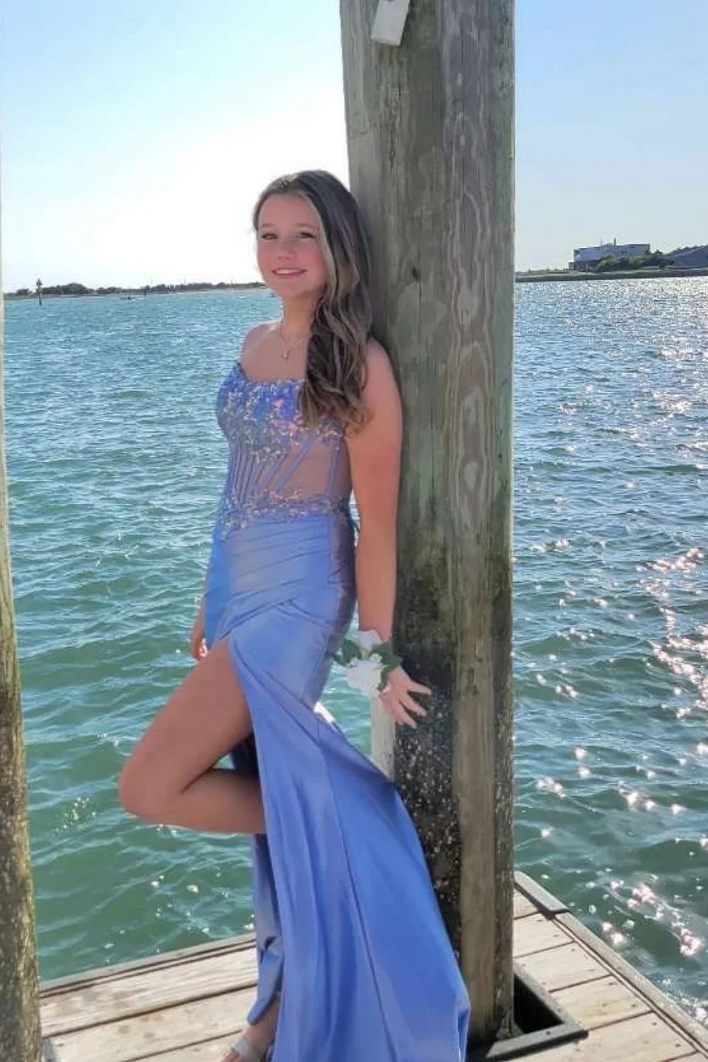 Blue A-line evening dress featuring a structured strapless corset-style bodice and a floor-length skirt with a leg slit.