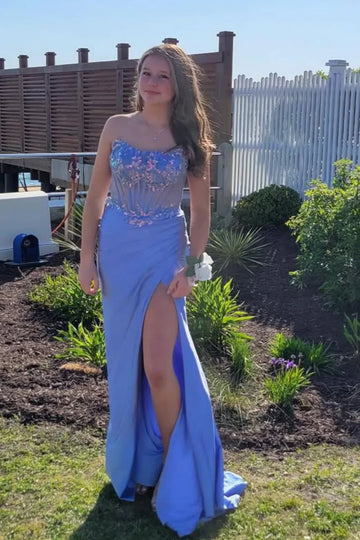 Blue A-line evening dress featuring a structured strapless corset-style bodice and a floor-length skirt with a leg slit.