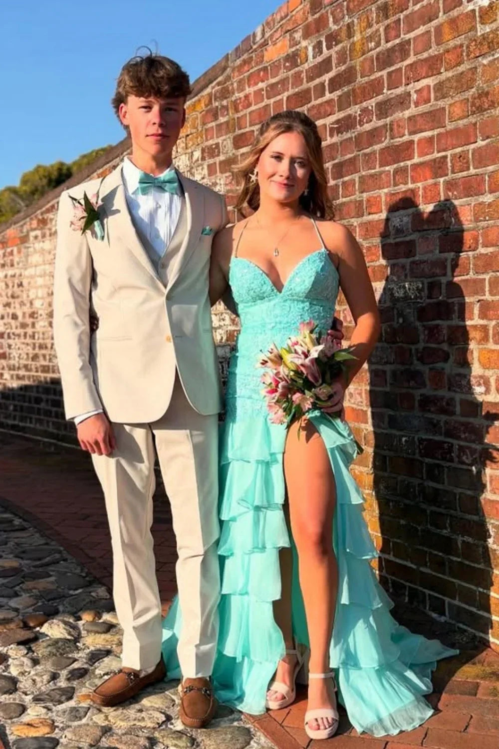 Sky blue A-line chiffon prom dress featuring delicate lace appliques, spaghetti straps, and a tiered ruffle skirt.