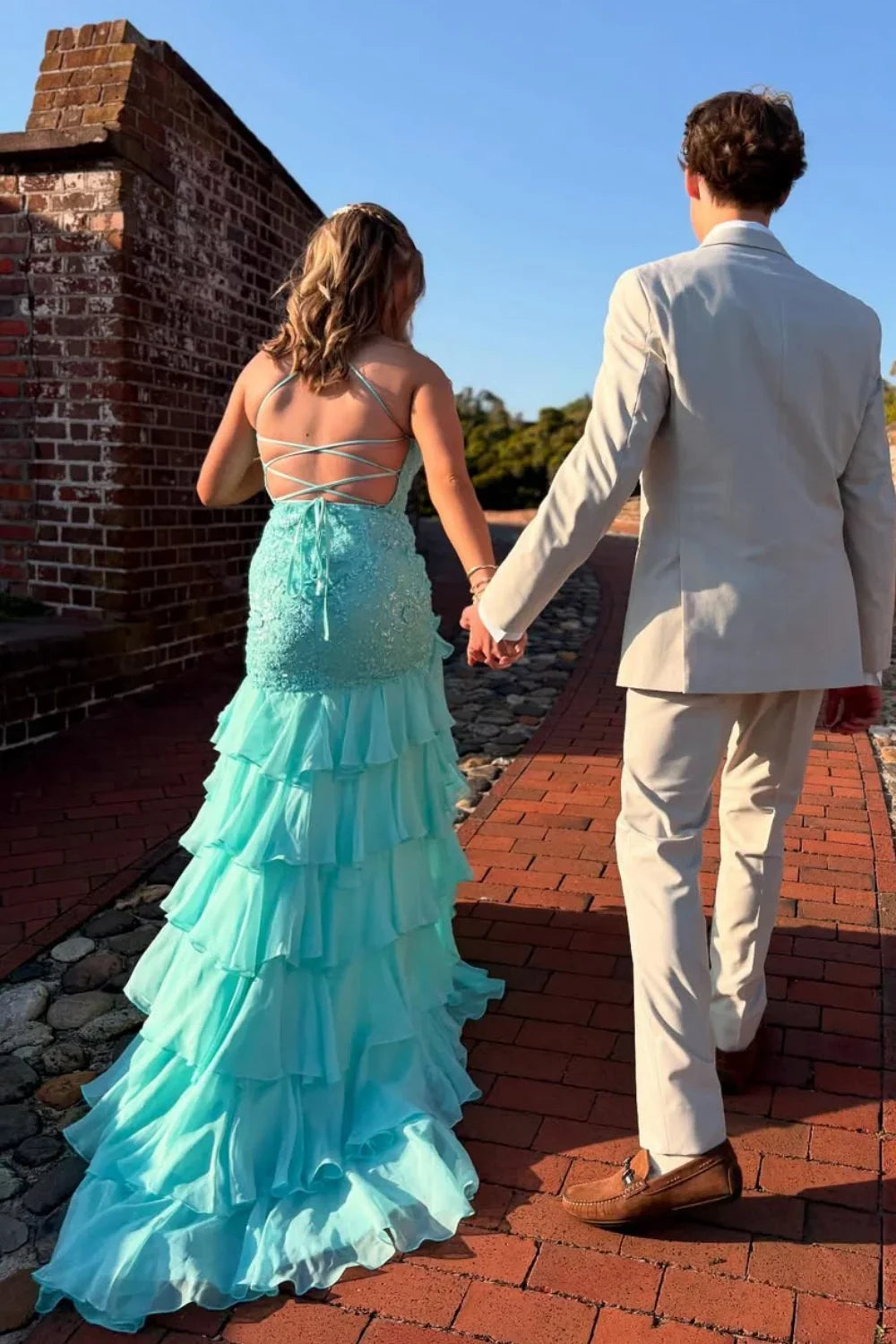 Sky blue A-line chiffon prom dress featuring delicate lace appliques, spaghetti straps, and a tiered ruffle skirt.