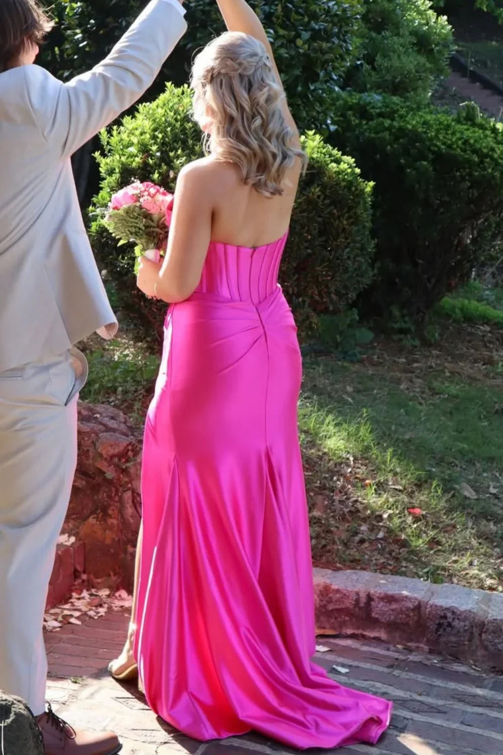 Bold fuchsia mermaid prom dress featuring a halter plunging V-neckline and elegant ruching throughout the bodice and skirt.