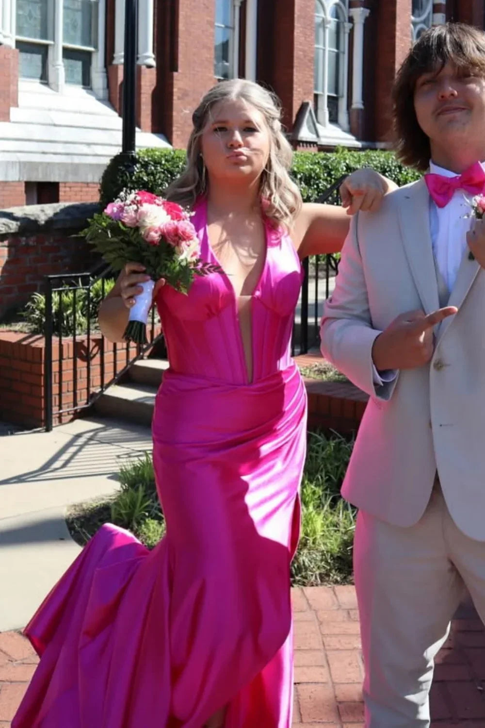 Bold fuchsia mermaid prom dress featuring a halter plunging V-neckline and elegant ruching throughout the bodice and skirt.