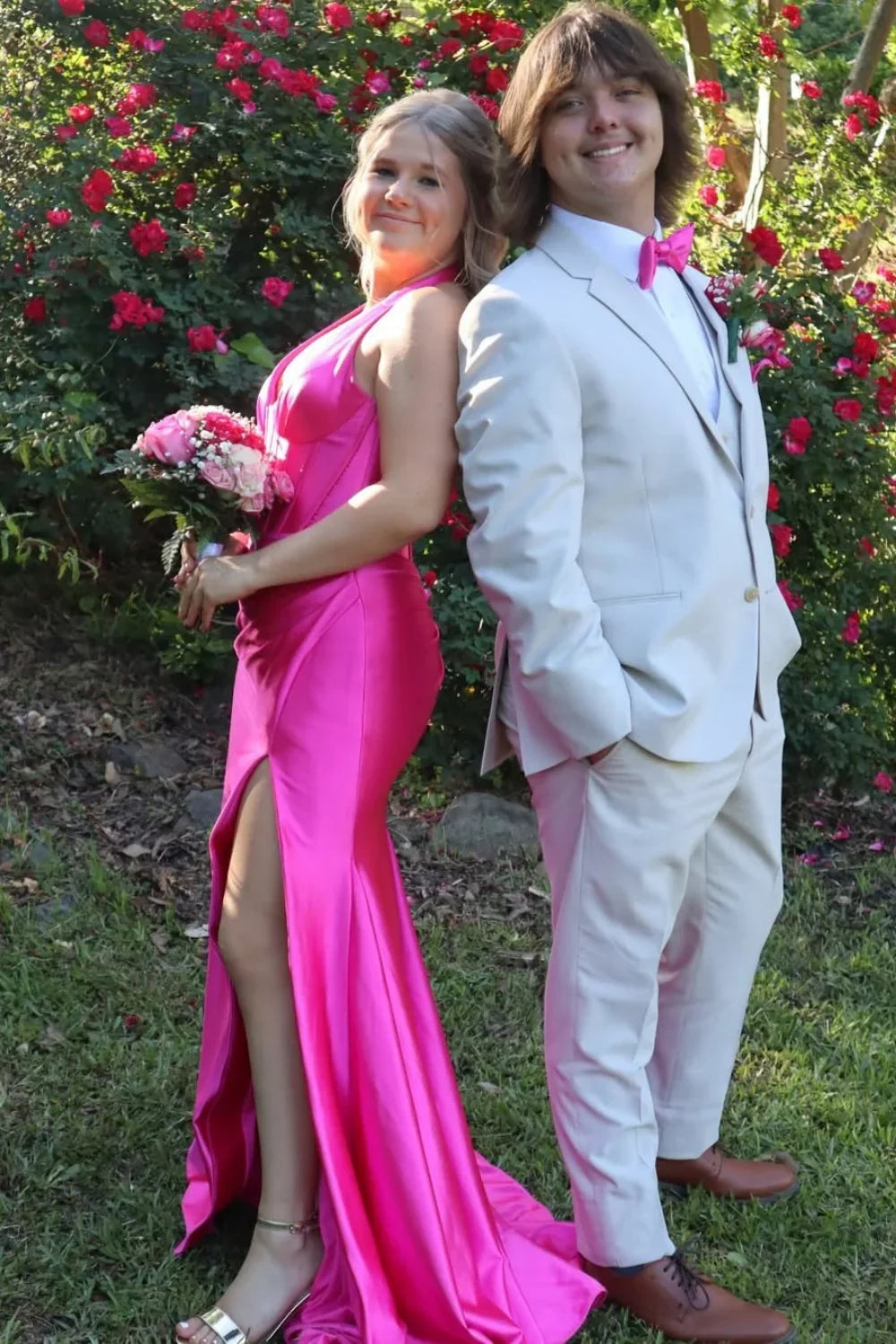 Bold fuchsia mermaid prom dress featuring a halter plunging V-neckline and elegant ruching throughout the bodice and skirt.