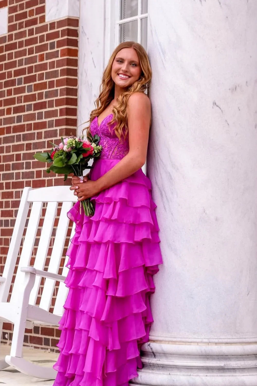 Purple A-line evening gown featuring a strapless neckline, delicate lace appliques, a tiered skirt, and a corset-style lace-up back.