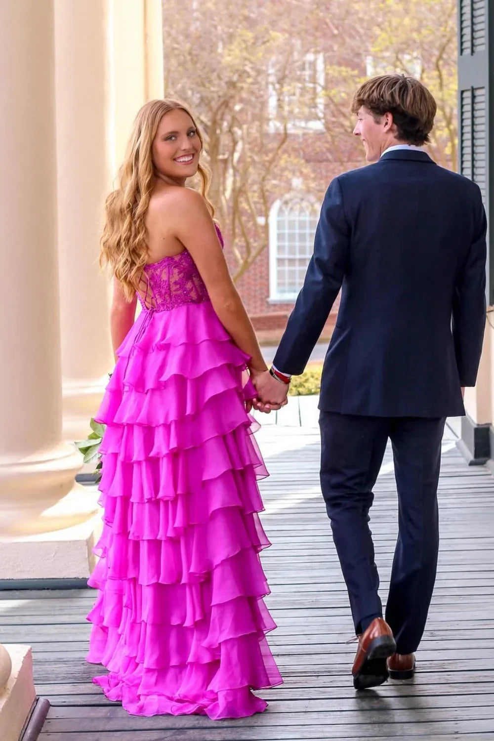 Purple A-line evening gown featuring a strapless neckline, delicate lace appliques, a tiered skirt, and a corset-style lace-up back.