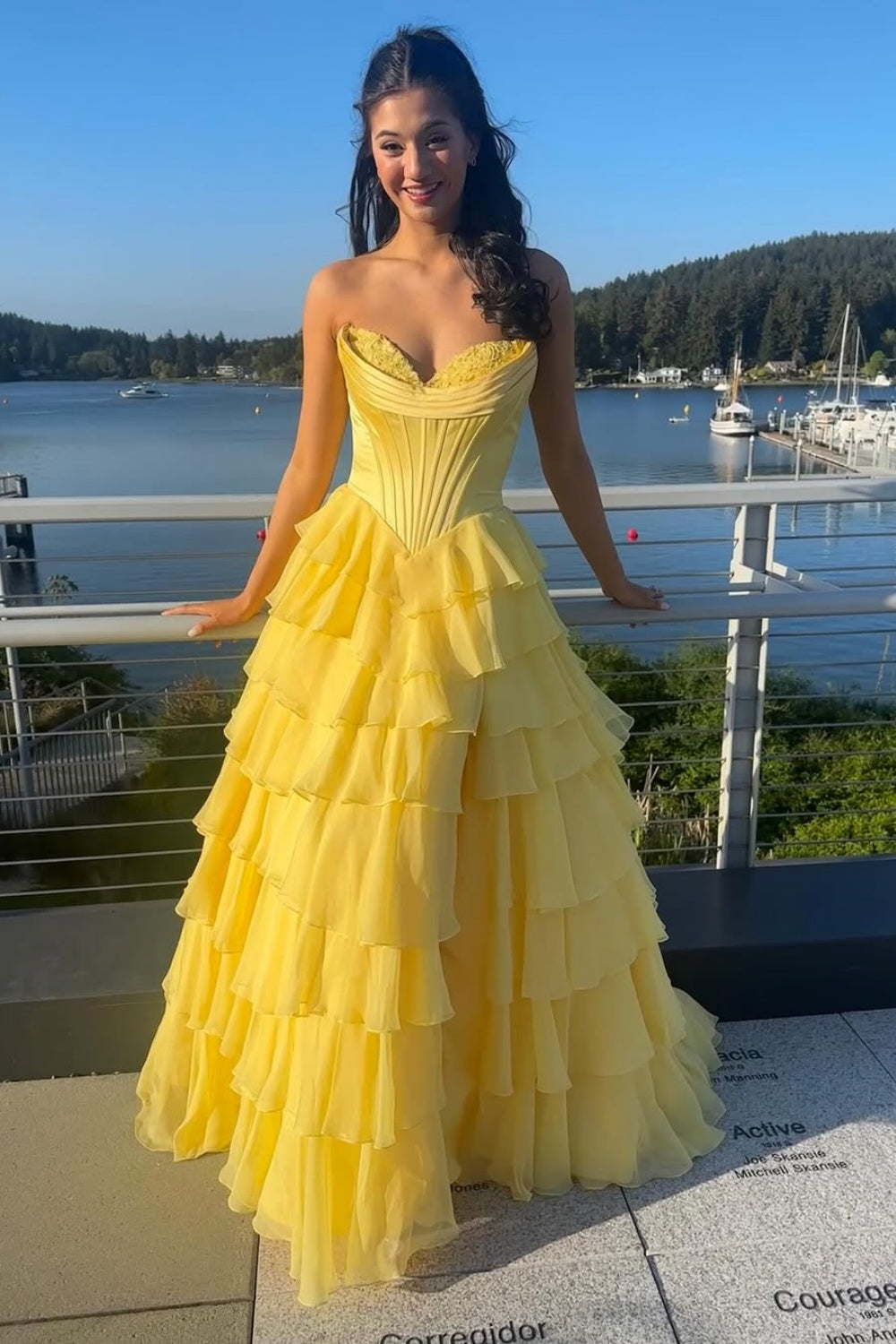 Bright yellow A-line formal gown featuring a sweetheart neckline, intricate lace appliques, and a voluminous tiered skirt.