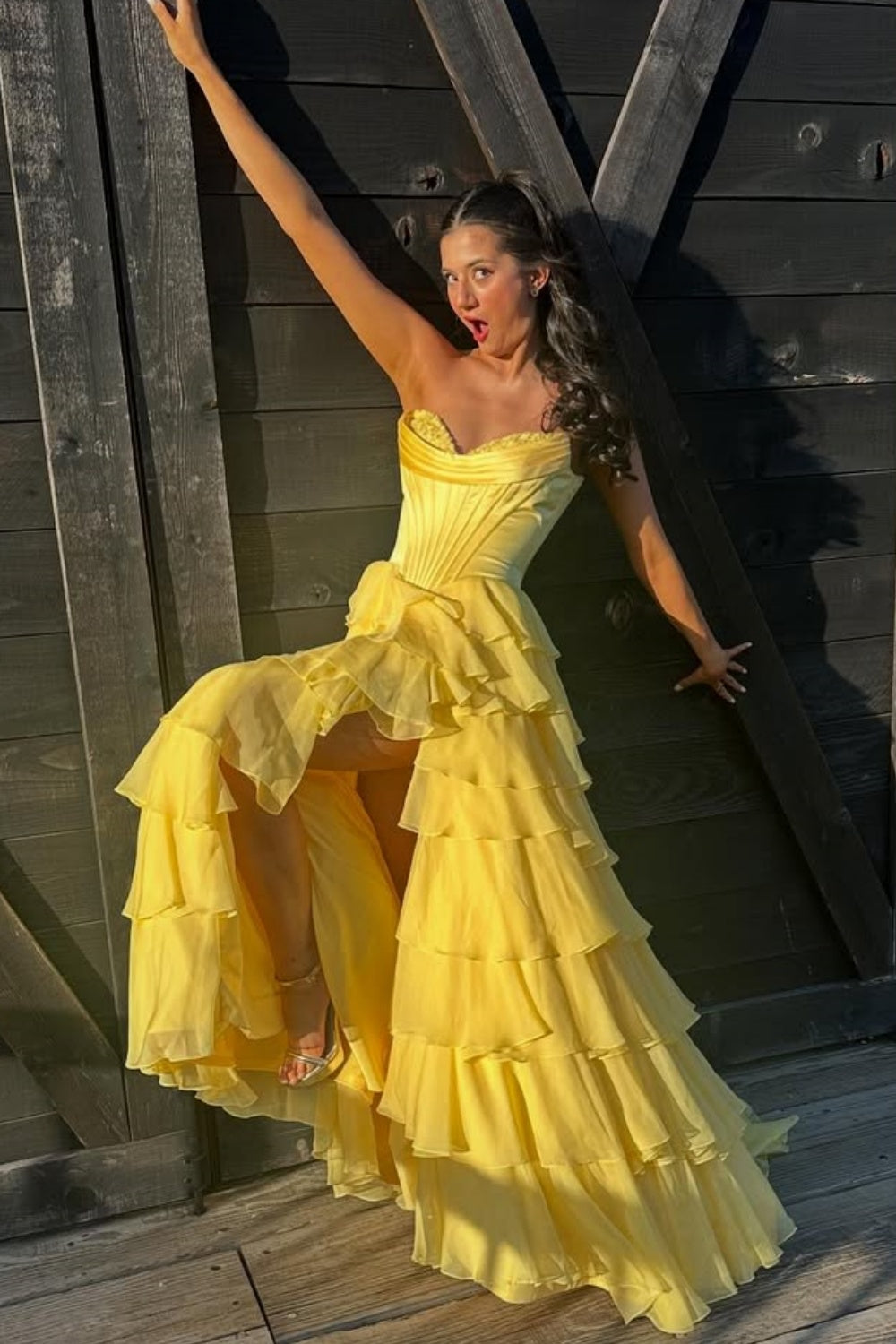 Bright yellow A-line formal gown featuring a sweetheart neckline, intricate lace appliques, and a voluminous tiered skirt.