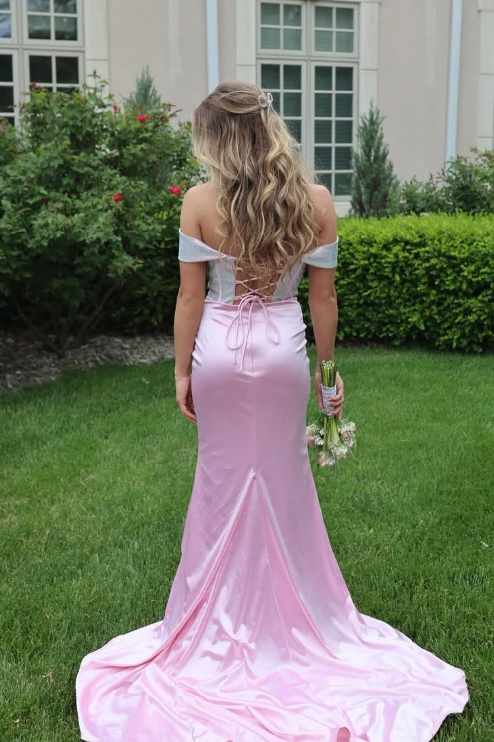 Pink off-the-shoulder mermaid dress with ruched corset and lace-up back.