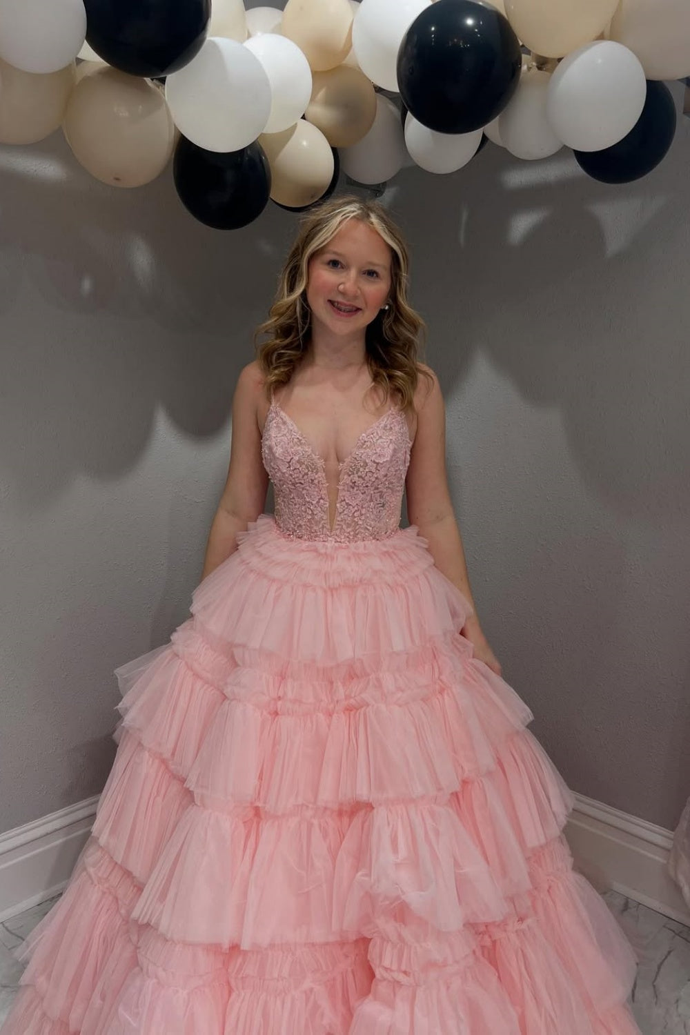 Pink tiered puff ball gown with spaghetti straps and lace appliques.