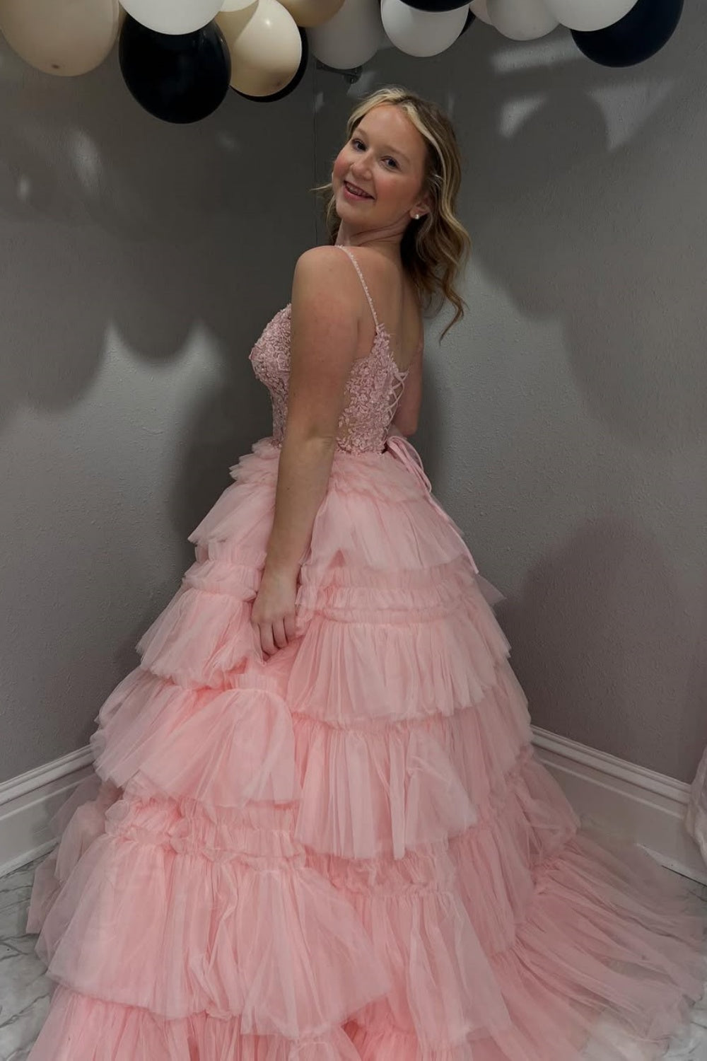 Pink tiered puff ball gown with spaghetti straps and lace appliques.