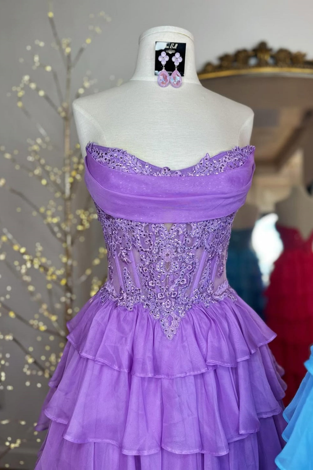 A-line tiered chiffon gown featuring a cowl neck and beaded lace appliques.