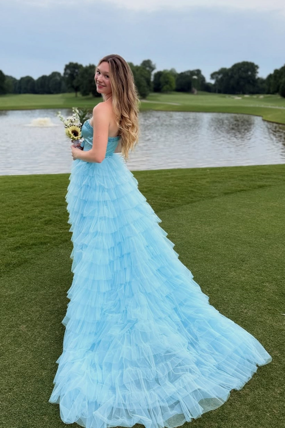Light blue sweetheart A-line prom gown with beaded bodice and ruffled tulle skirt.