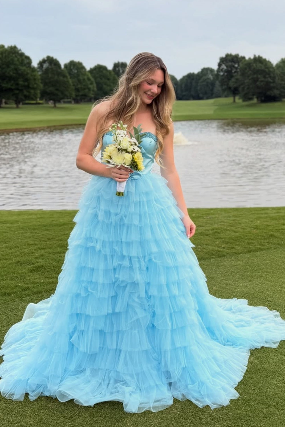 Light blue sweetheart A-line prom gown with beaded bodice and ruffled tulle skirt.