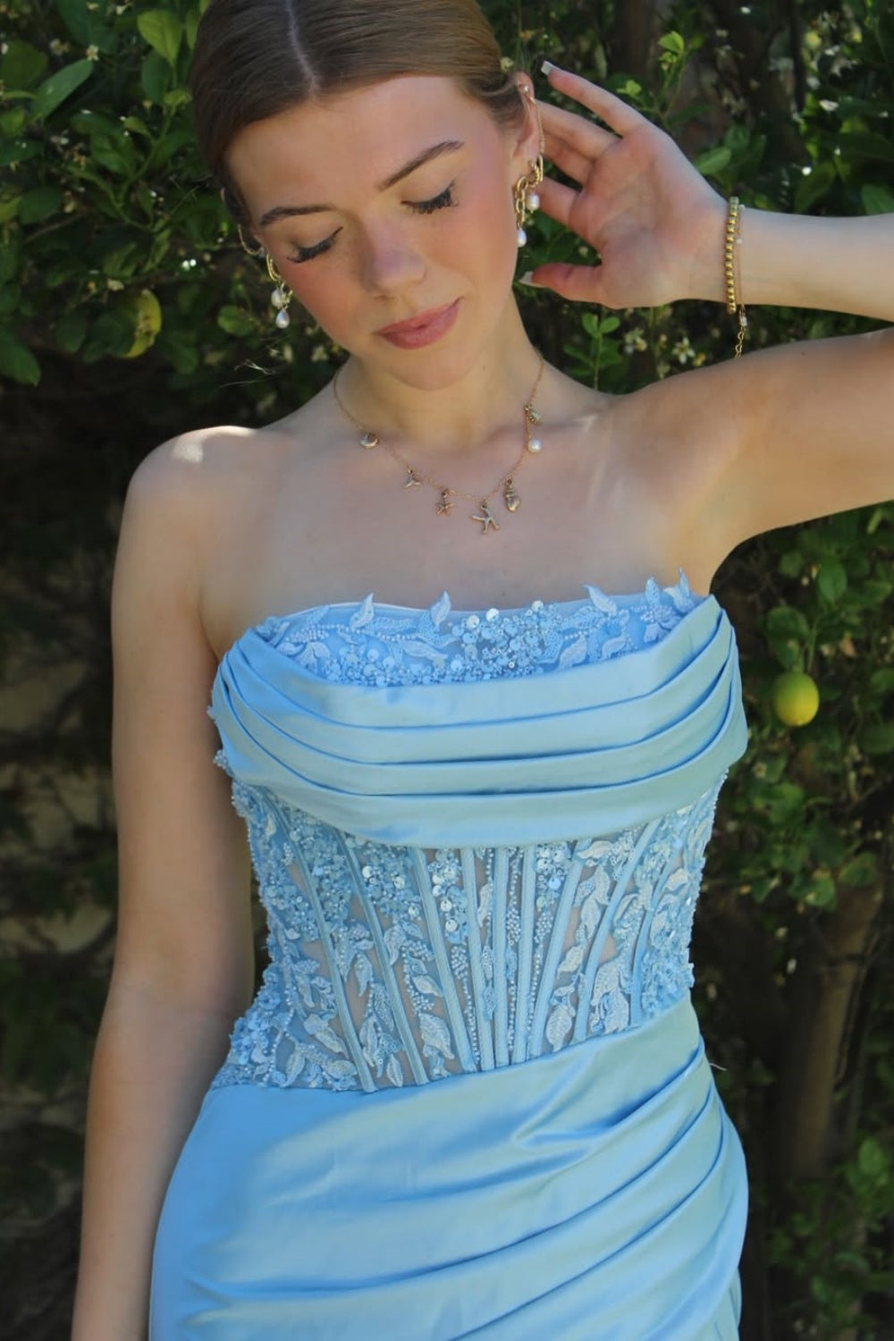 Light blue strapless mermaid prom gown with intricate lace appliques and silver beadwork.