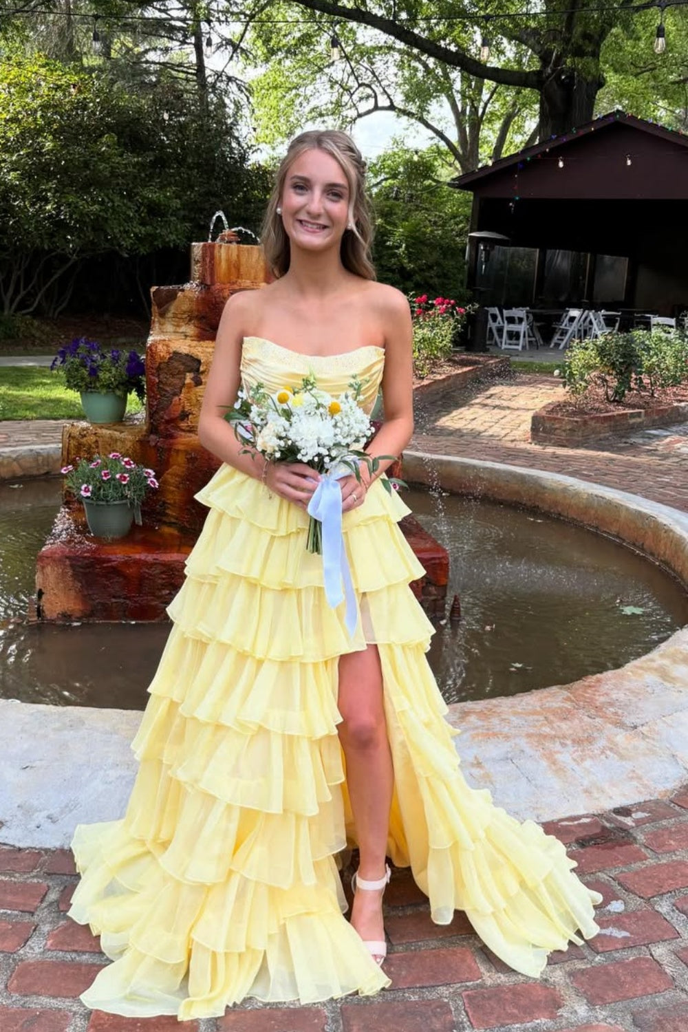 Yellow strapless A-line floor-length chiffon gown with corset bodice and beaded ruffles.