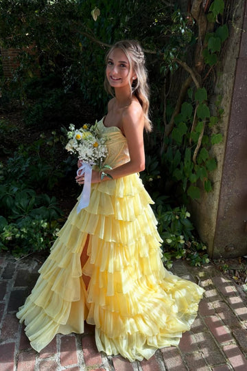 Yellow strapless A-line floor-length chiffon gown with corset bodice and beaded ruffles.