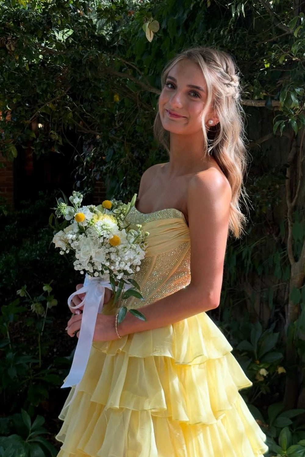 Yellow strapless A-line floor-length chiffon gown with corset bodice and beaded ruffles.