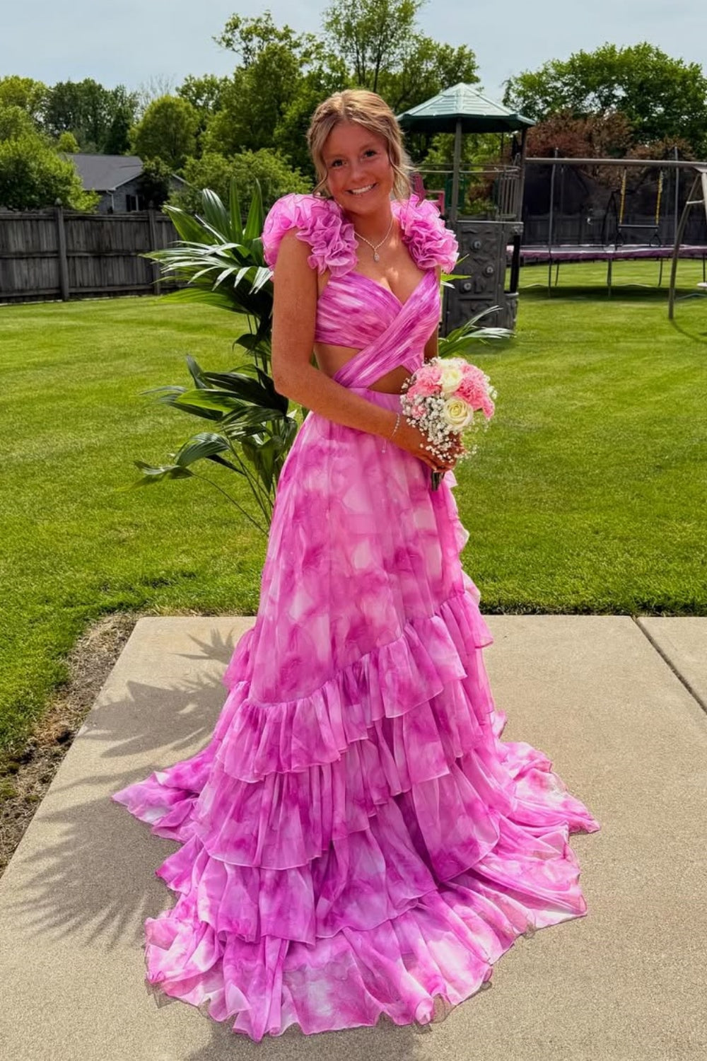 A-line prom dress featuring 3D floral appliques, cross design bodice, and ruffle skirt.