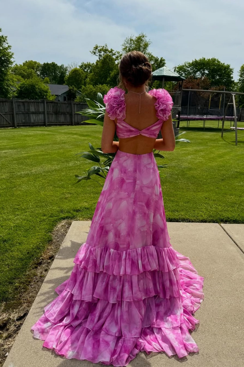 A-line prom dress featuring 3D floral appliques, cross design bodice, and ruffle skirt.