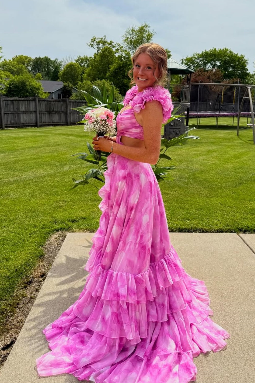 A-line prom dress featuring 3D floral appliques, cross design bodice, and ruffle skirt.