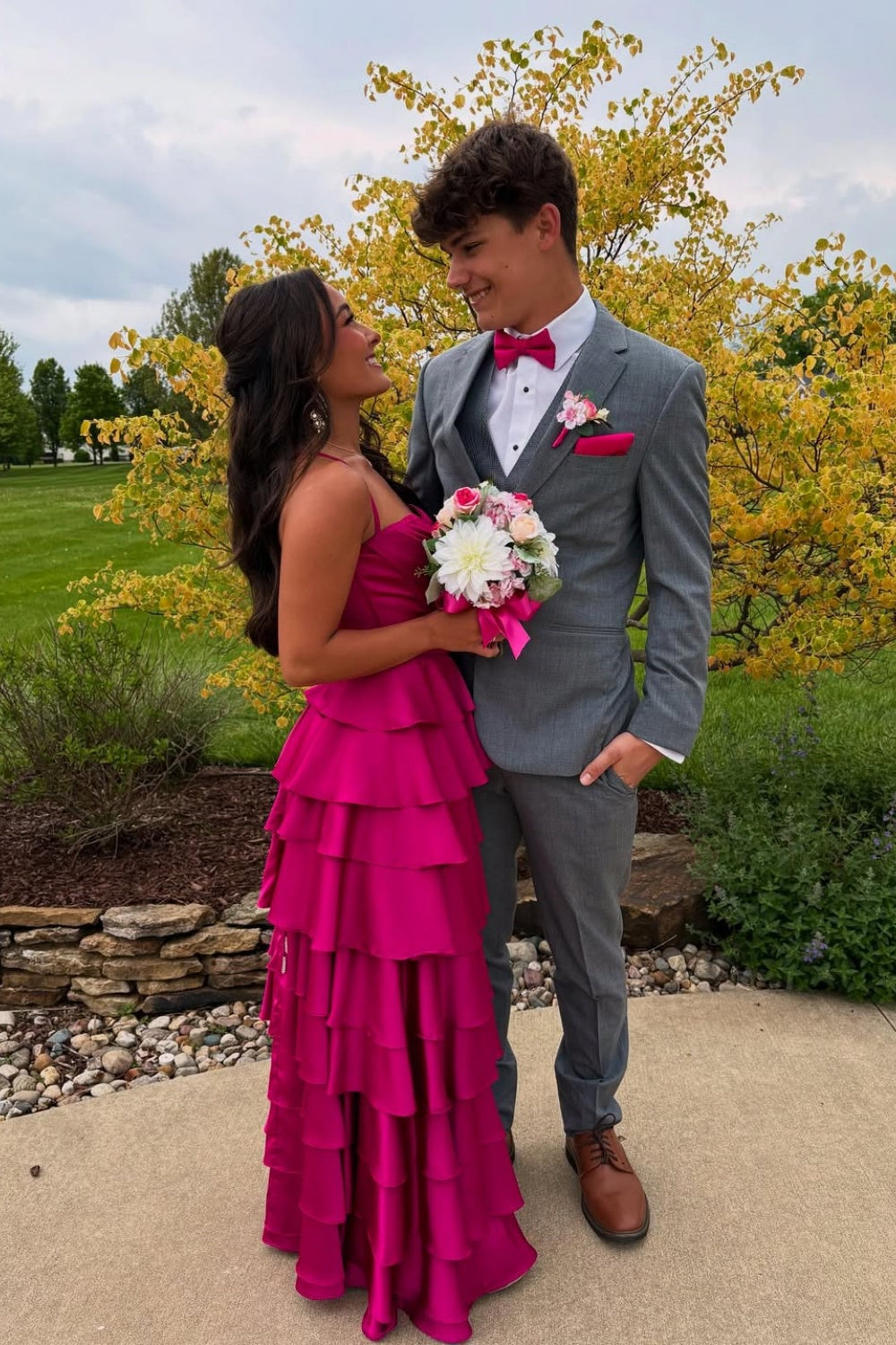 Fuchsia A-line formal prom dress with spaghetti straps, ruffled skirt, and side slit.