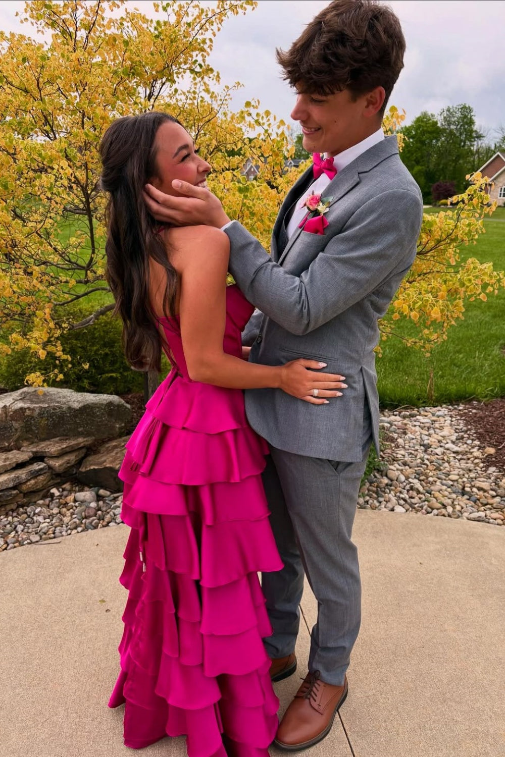 Fuchsia A-line formal prom dress with spaghetti straps, ruffled skirt, and side slit.