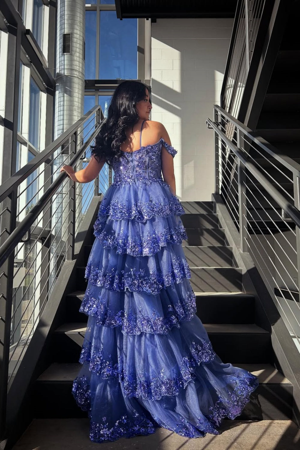 Blue off-the-shoulder A-line gown with sequins, lace appliques, and a tiered ruffle skirt.