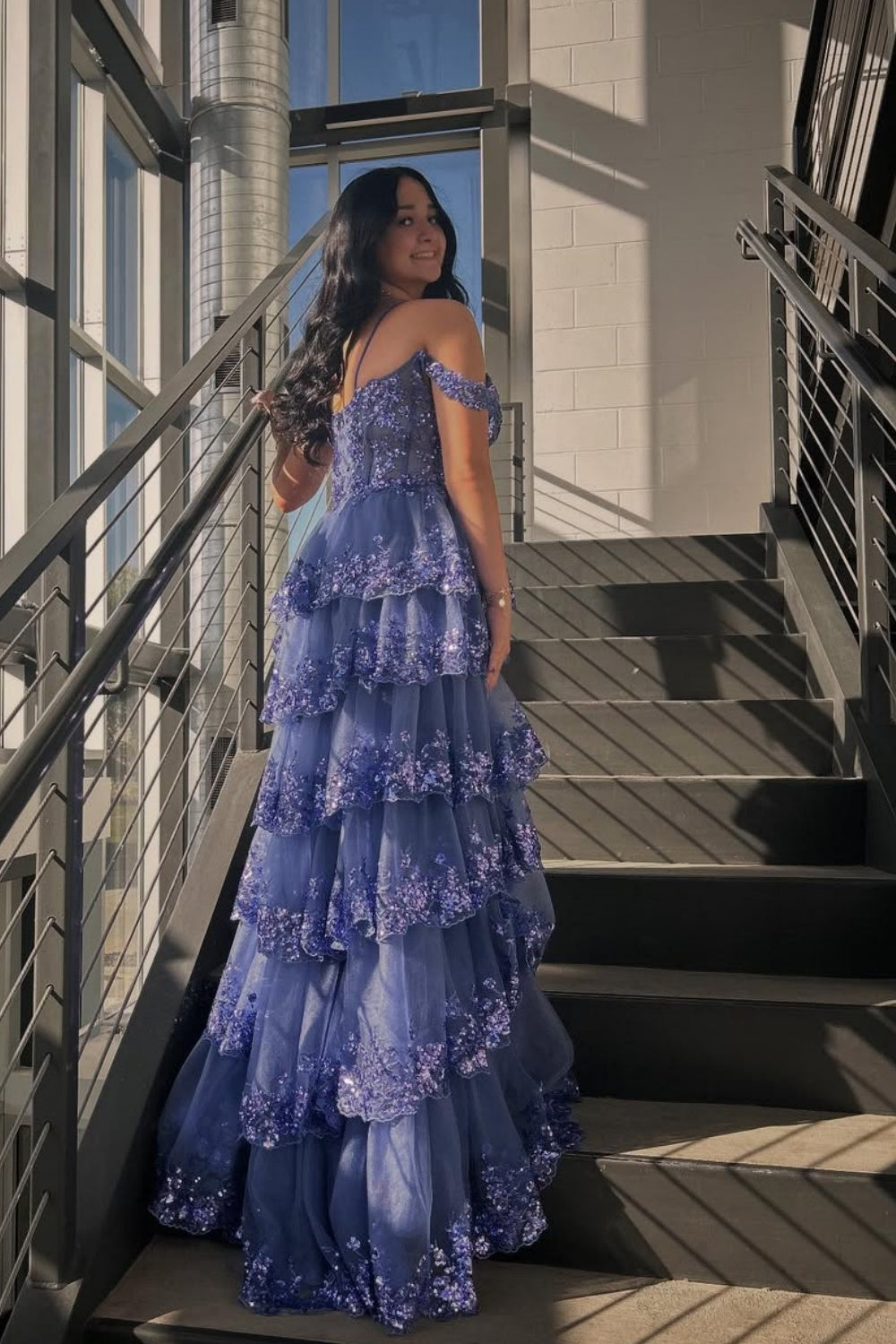 Blue off-the-shoulder A-line gown with sequins, lace appliques, and a tiered ruffle skirt.
