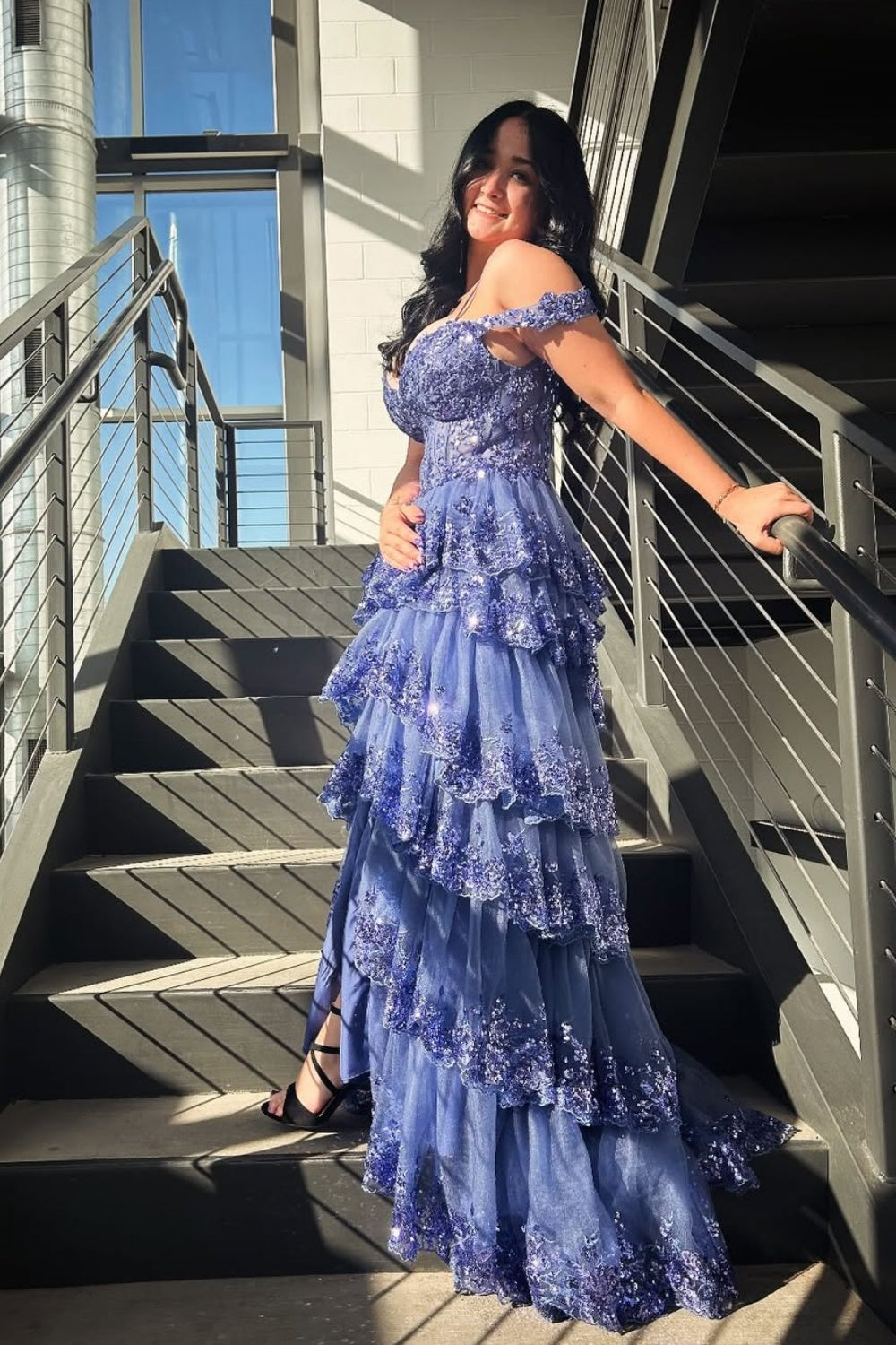 Blue off-the-shoulder A-line gown with sequins, lace appliques, and a tiered ruffle skirt.