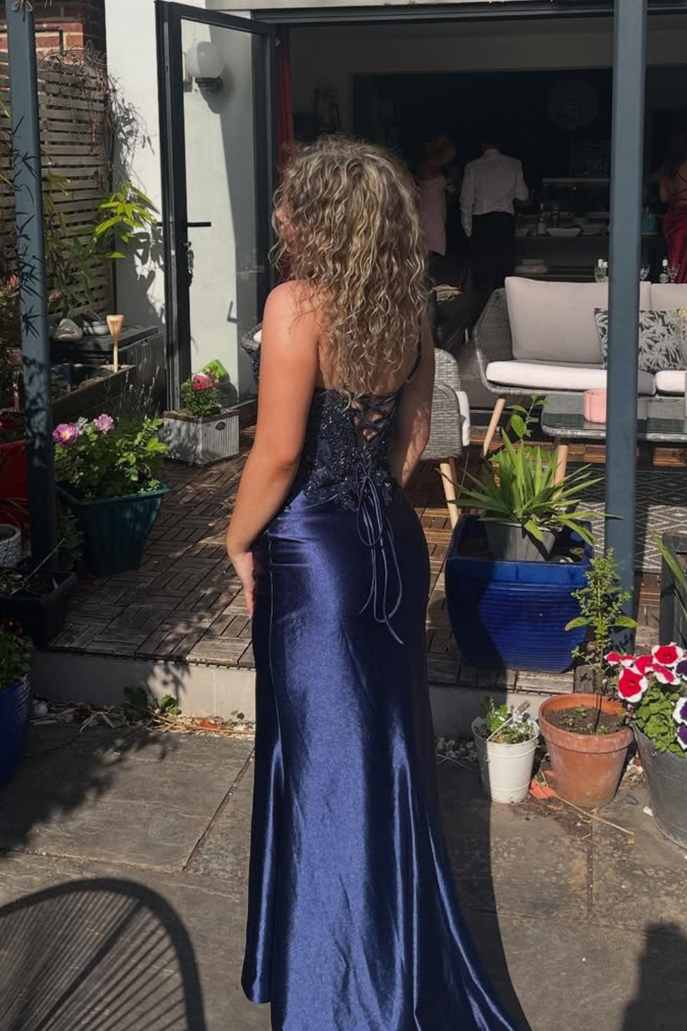 Navy blue mermaid prom dress with lace appliques, ruched bodice, side slit, and beaded detailing.