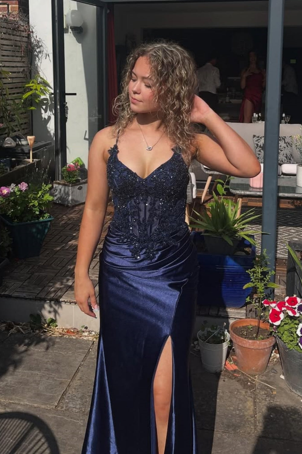 Navy blue mermaid prom dress with lace appliques, ruched bodice, side slit, and beaded detailing.