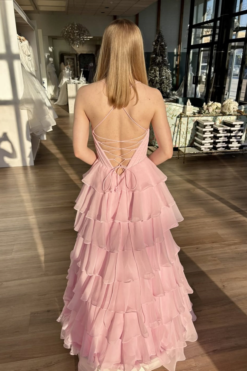 Pink chiffon A-line tiered prom dress with spaghetti straps and lace-up back.