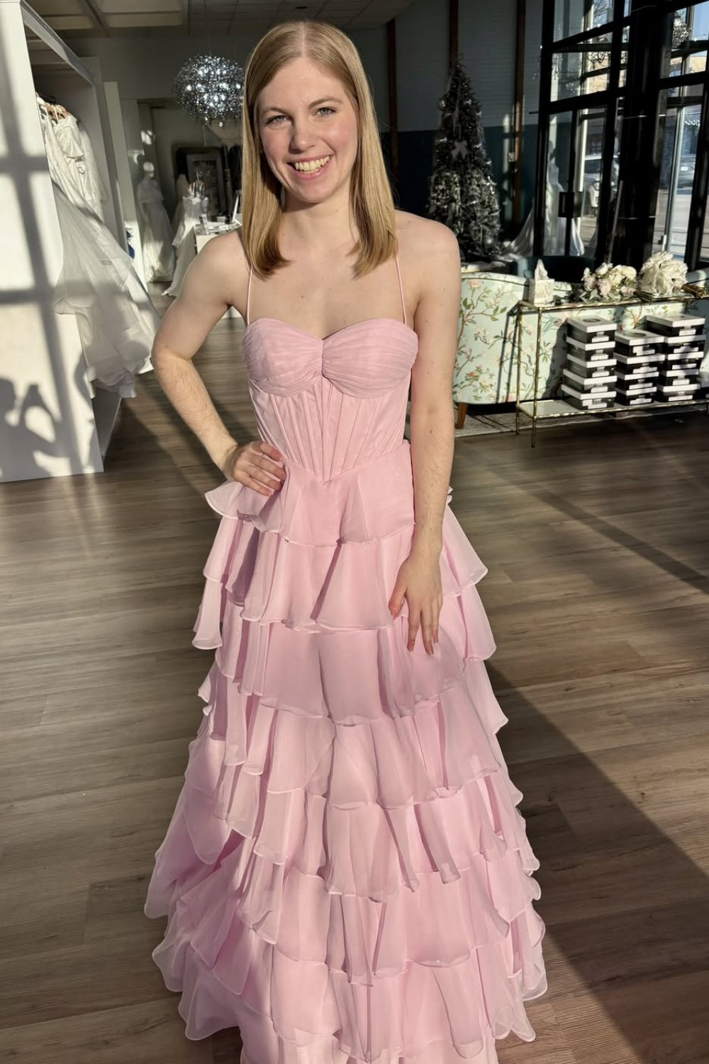 Pink chiffon A-line tiered prom dress with spaghetti straps and lace-up back.