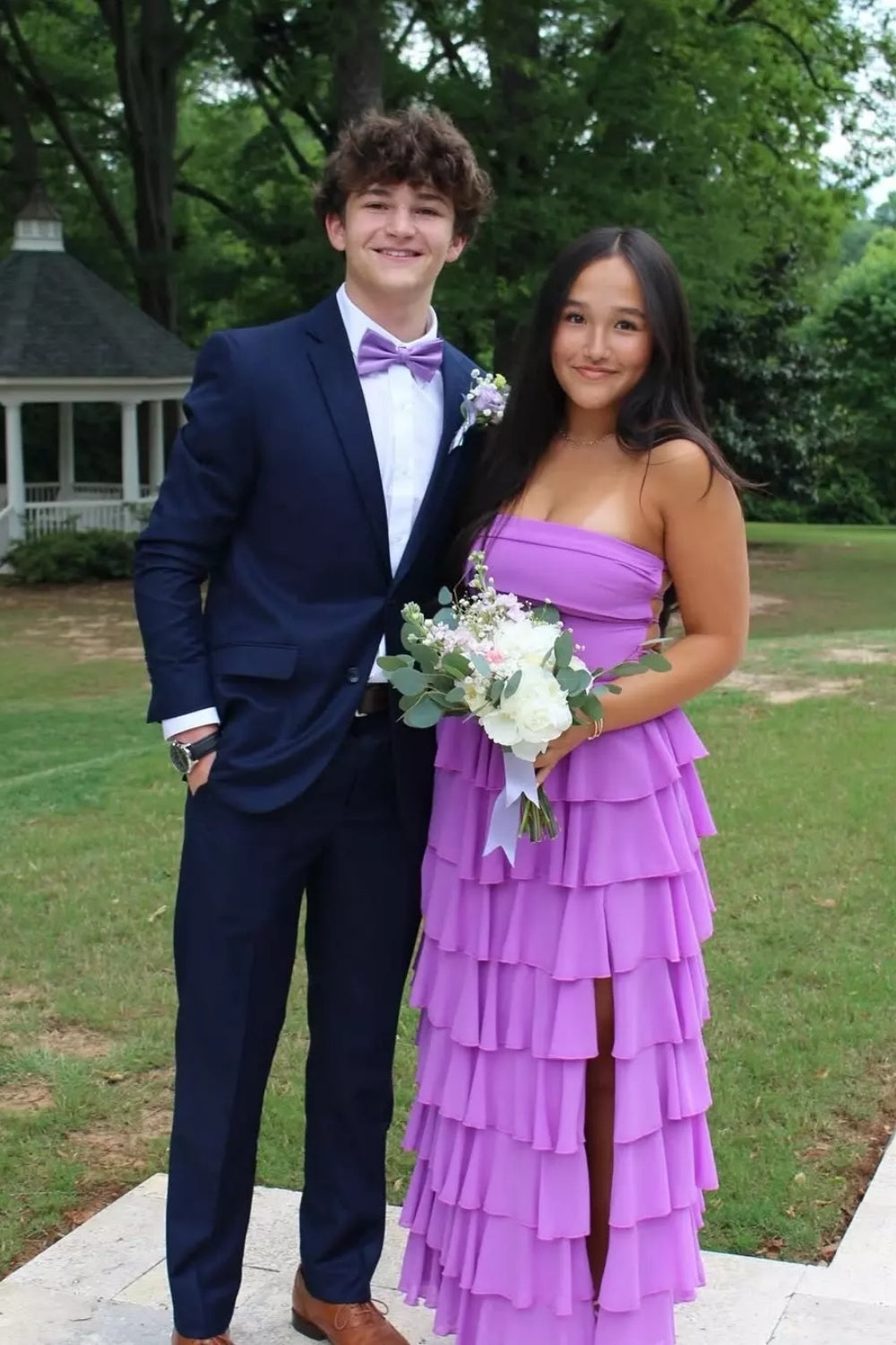 Strapless purple A-line chiffon prom dress with tiered skirt and side slit.