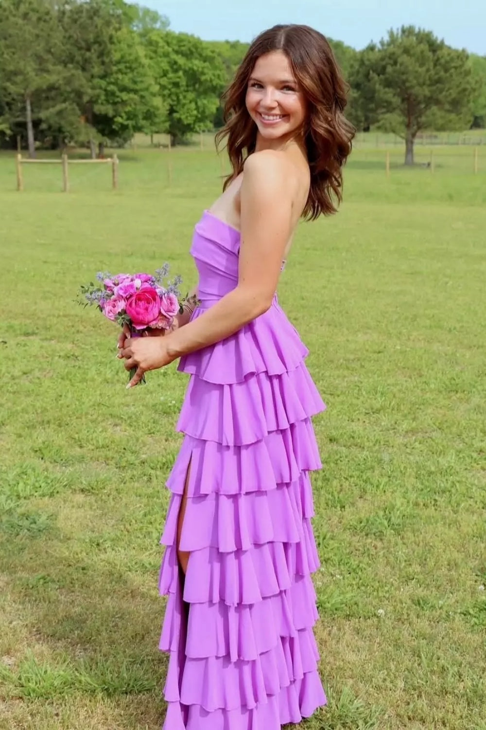 Strapless purple A-line chiffon prom dress with tiered skirt and side slit.