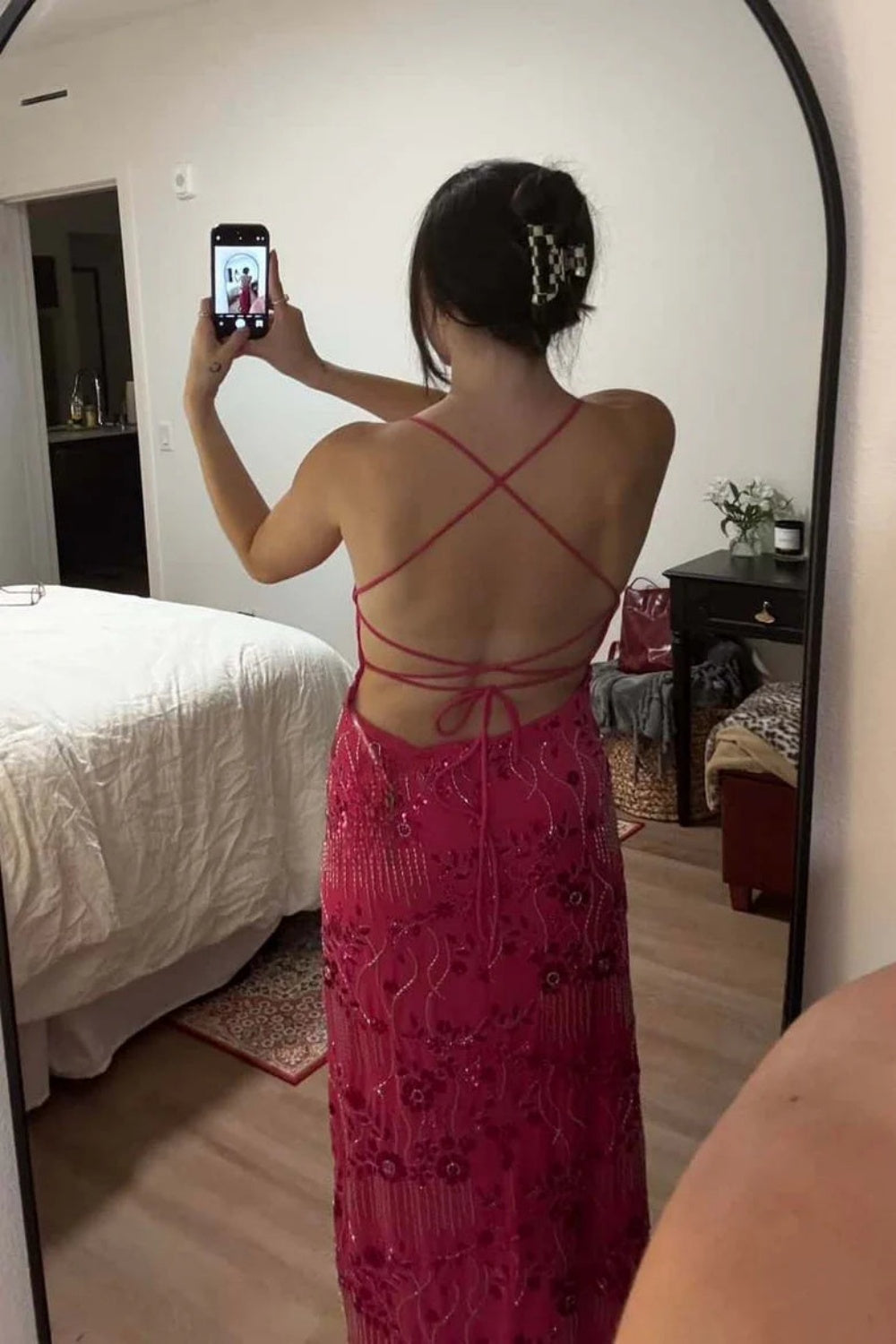 Fuchsia fitted long dress with spaghetti straps, intricate beading, and floral decorations.