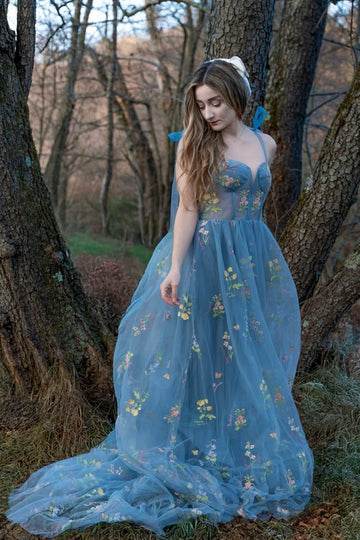 Blue A-line tulle prom dress with flower appliques and bow straps.
