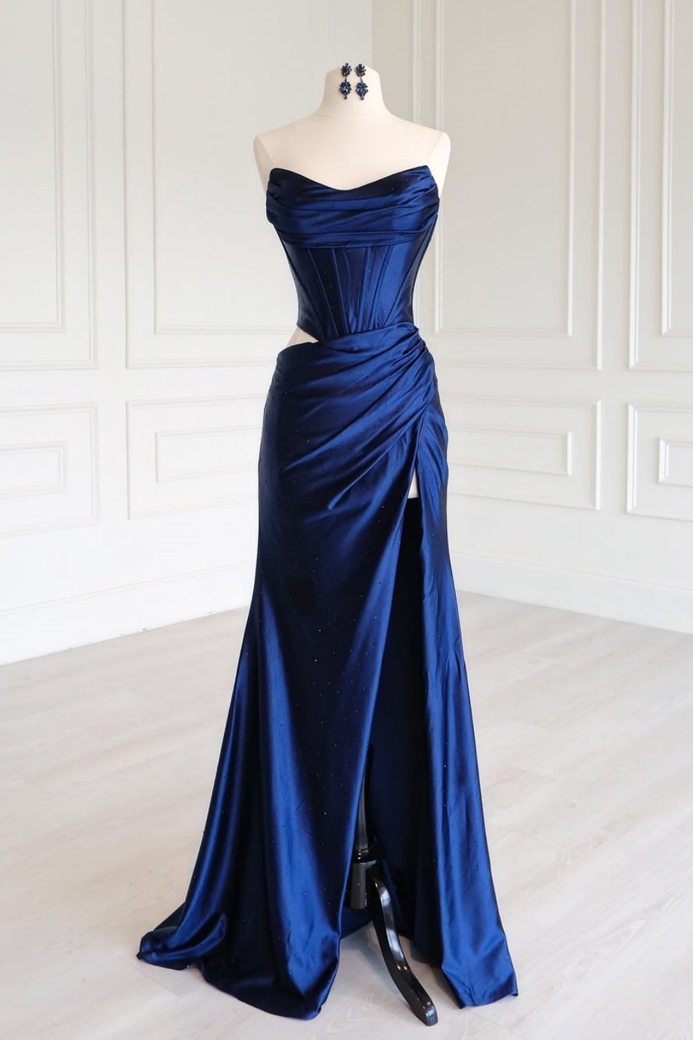 Navy blue strapless beaded formal dress with ruched cut-out and leg slit.