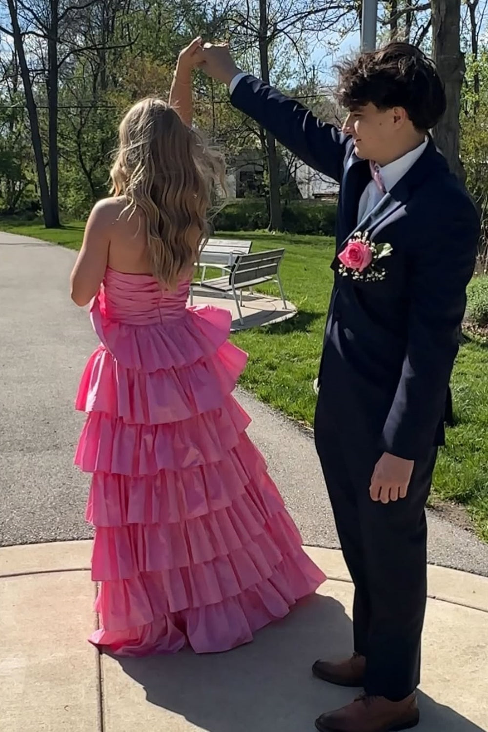 Pink strapless A-line tiered prom gown with ruched bodice and side slit.