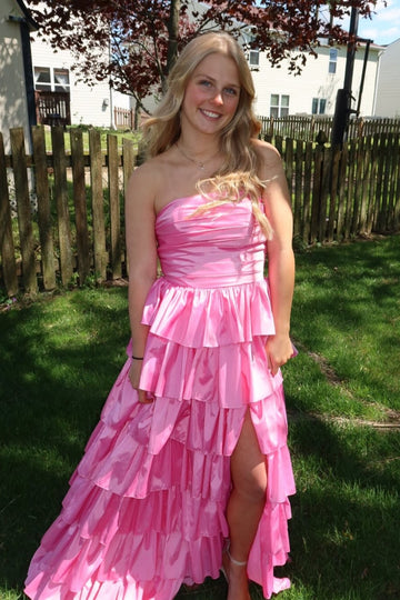 Pink strapless A-line tiered prom gown with ruched bodice and side slit.