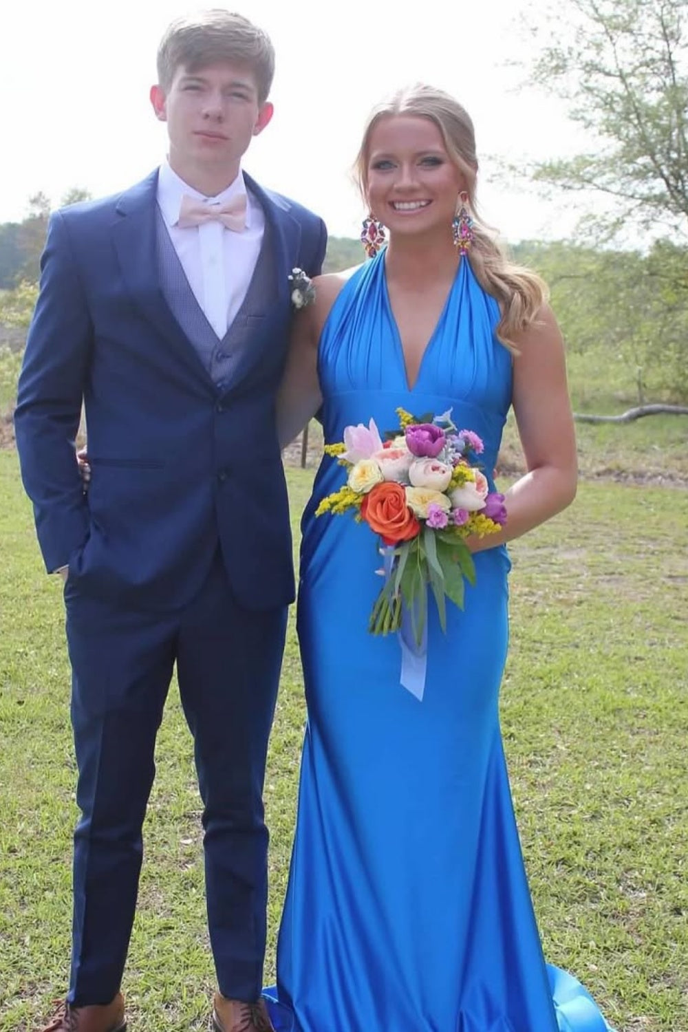Satin halter mermaid prom dress featuring a large back bow and open back.