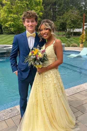 Yellow A-line tulle prom dress with floral lace appliques and plunging V-neck.