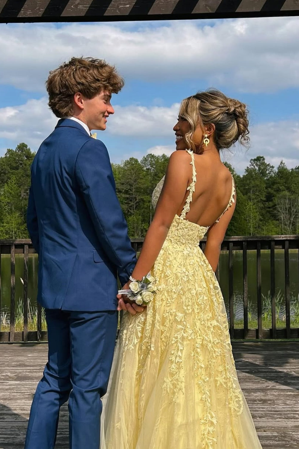 Yellow A-line tulle prom dress with floral lace appliques and plunging V-neck.
