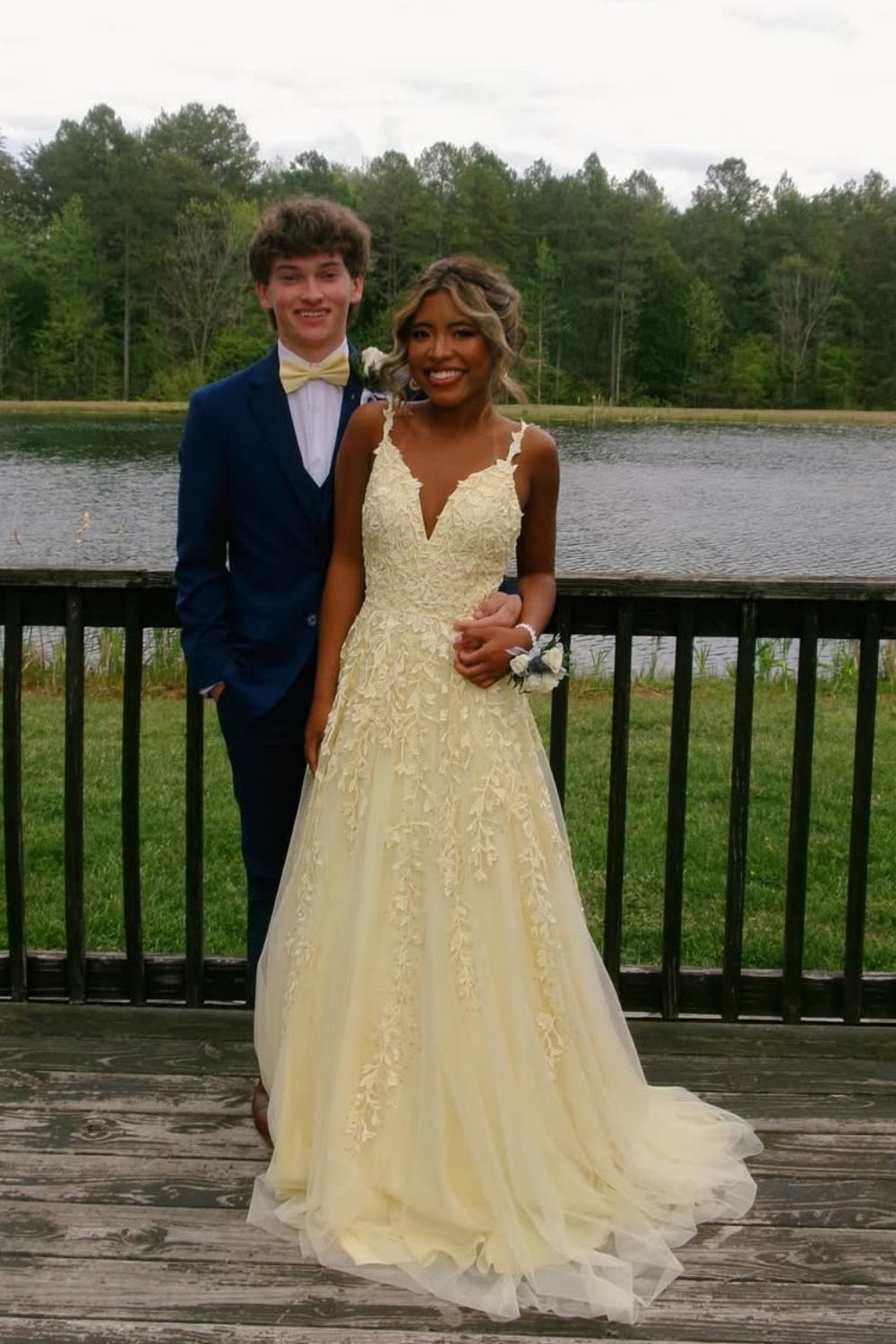 Yellow A-line tulle prom dress with floral lace appliques and plunging V-neck.