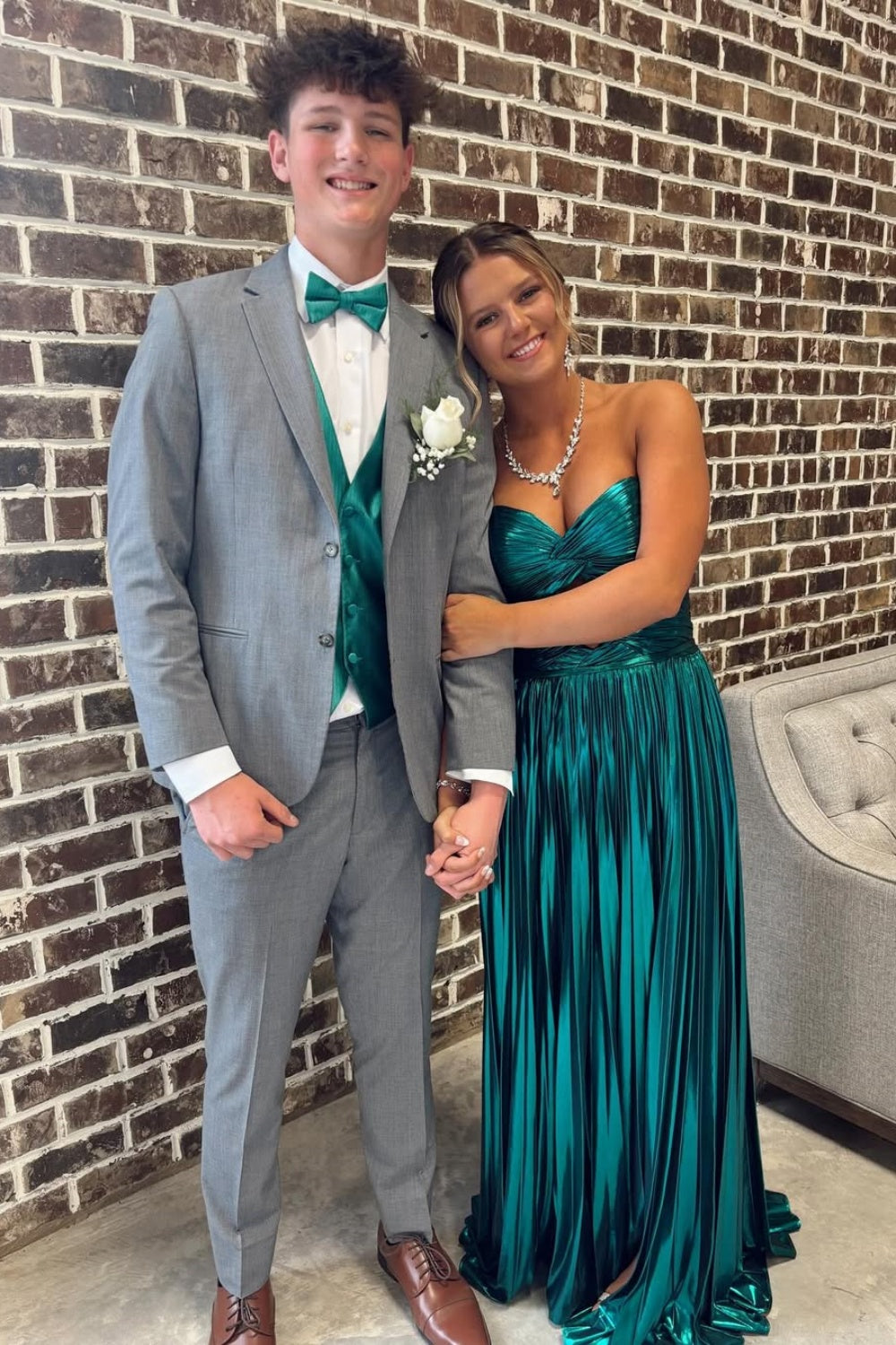 Metallic green strapless pleated A-line prom dress with twist keyhole detail.